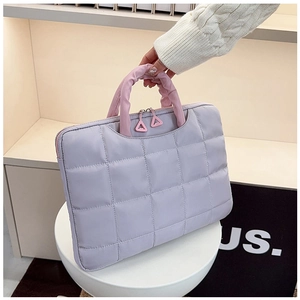 Detail of light purple quilted document bag with pink ruched handles and double zippers