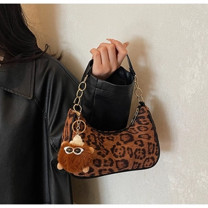 Detail of vintage leopard print suede hobo bag with gold chain and plush charm