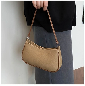 Detail van kaki canvas baguette tas met bruine lederen bies en zilveren metalen ringbeslag