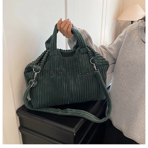 Detailopname van donkergroene corduroy stof en 3D-borduurwerk op deze tote bag