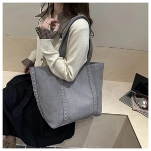 Detail view of grey tote bag with silver studs and premium matte texture for daily work