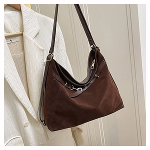Detail of dark brown suede hobo bag featuring matte texture and metal buckle accents
