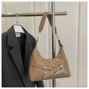 Detail of khaki glossy underarm bag showing buckle strap and polished leather texture