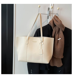 Detail of minimalist cream tote bag with thin straps and FASHION & BAG lettering
