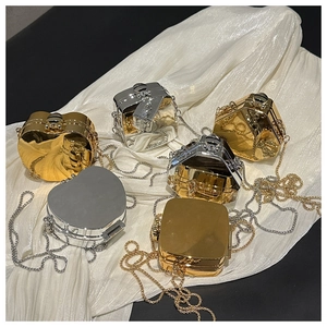 Close-up of geometric mini metal clutch bags with gold and silver acrylic chains