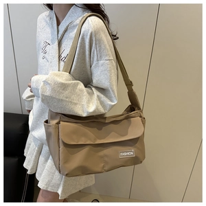 Khaki messenger bag detail showing spacious main compartment and adjustable strap on a model