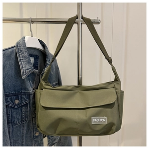Détail du sac bandoulière en nylon vert armée avec étiquette mode et sangle réglable