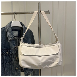 Détail du sac fourre-tout en nylon blanc avec poche à rabat et étiquette de mode