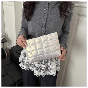 Close-up of silver quilted metallic cosmetic bag with a glossy laser finish
