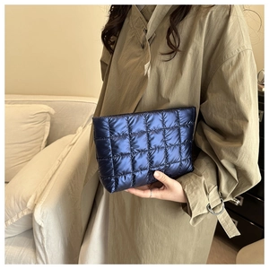 Detailed shot of dark blue metallic quilted bag with puffer texture and grid pattern