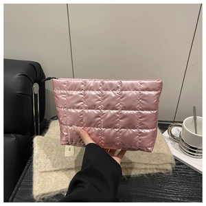 Close-up of pink quilted puffer cosmetic bag with metallic finish and black zipper