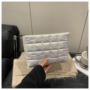 Detailed view of silver quilted makeup bag texture with metallic finish and chic design