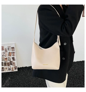 Close-up of cream textured leather handbag featuring gold Fashion & Bags logo detail