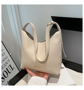 Close-up of cream lychee-textured leather hobo bag with gold Fashion & Bags lettering