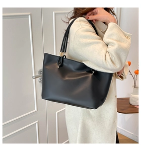 Photo de mode d'un grand sac cabas noir en similicuir avec boucles dorées élégantes