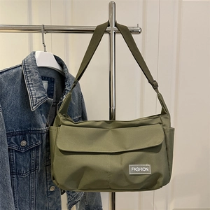 Sac bandoulière en nylon vert armée avec large sangle et étiquette de mode sur portant