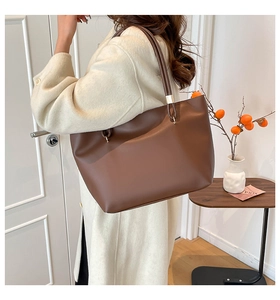 Gros plan d'un sac cabas en cuir marron porté pour montrer sa taille et son design chic