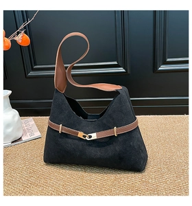 Detail of black suede tote bag with brown leather straps and vintage gold buckle hardware