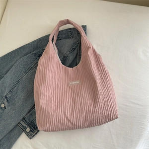 Makroaufnahme einer rosa Falten-Einkaufstasche mit transparentem Fashion-Logo-Patch