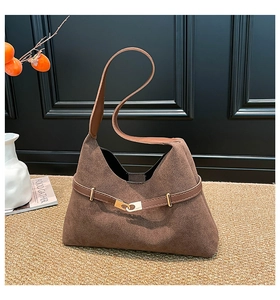 Close-up of brown suede hobo bag featuring a sleek leather strap and gold buckle detail