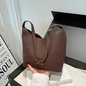Dark brown pebbled leather fashion handbag with gold text shown in premium gift box