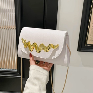 Modern white leather shoulder bag with gold wave buckle and chain strap shown with a model
