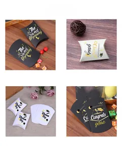 Close-up of pillow-shaped graduation candy boxes with gold foil Congrats Grad lettering