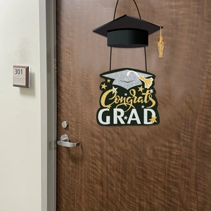 Black graduation cap door hanger with gold Congrats GRAD glitter sign on a wooden door