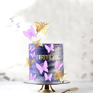 Macro view of golden hollow butterfly toppers and birthday sign on a marbled cake