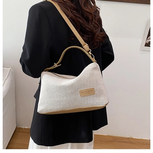 Detail of knit shoulder bag with leather accents on model in black blazer