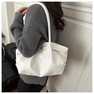 Détail de la texture cuir grainé blanc et du design plissé du sac cabas pour femme