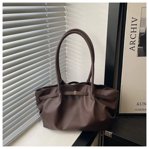 Détail du sac cabas en cuir marron foncé avec texture plissée et boucle dorée carrée