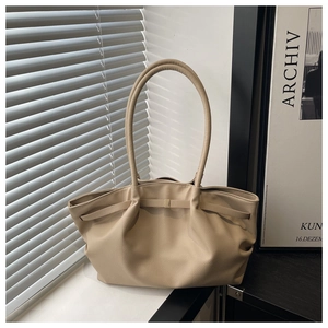 Détail d'un sac cabas plissé beige en cuir grainé avec une texture douce et élégante