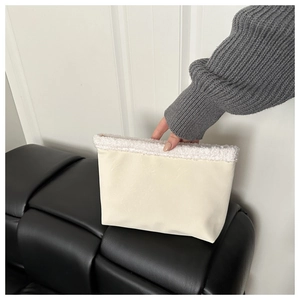 Detail of cream clutch with white faux fur trim showing soft texture and premium finish