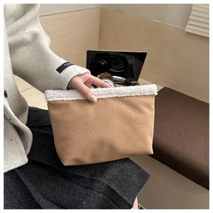 Detailed texture of khaki pleated faux leather and soft white fleece trim on hand bag