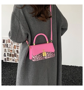 Detail of pink leopard print handbag with gold buckle on grey tweed coat