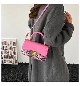 Detail of pink leather and leopard print handbag with gold lock and shoulder strap