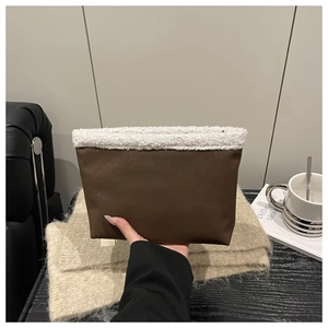 Detailed close-up of brown suede bag with plush white sherpa trim and zip closure