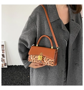 Detail of a vintage leopard print crossbody bag styled with a grey wool coat on a model
