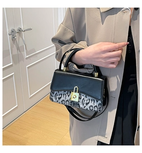 Close-up of leopard print pattern and gold twist lock on women's retro shoulder bag