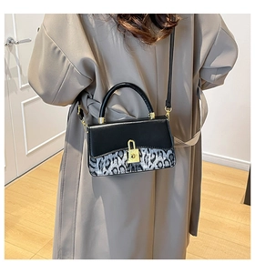 Detail of crossbody bag with leopard print flap worn with a beige trench coat