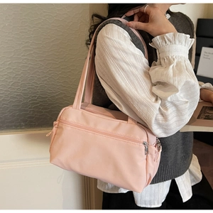 Detail view of pink canvas tote bag showing multiple zipper pockets and smooth metal hardware