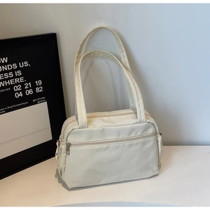 Detail of minimalist cream canvas tote bag with front zipper pocket and adjustable straps
