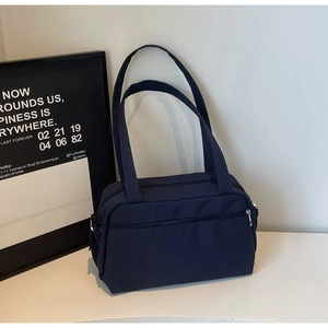 Close-up of navy nylon tote bag with dual zippers and water-resistant texture