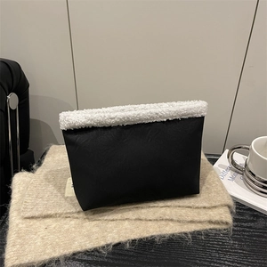 Vintage suede shoulder bag with black fabric and white faux fur trim in a lifestyle setting