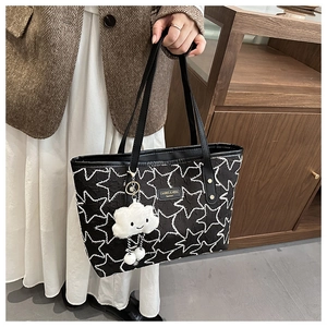 Detail of black quilted tote bag with white star pattern and fluffy cloud charm