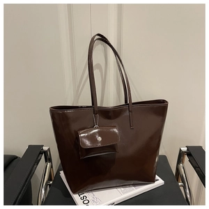 Detail of a large dark coffee tote bag with a glossy finish and matching small pouch
