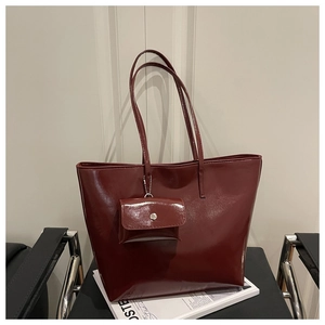 Macro detail of wine red glossy leather tote bag with matching mini coin pouch