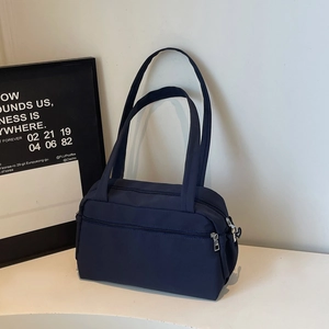 Minimalist navy blue canvas tote bag with front zipper pocket for daily commute use