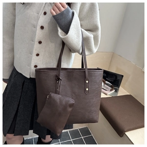 Detail of deep brown textured leather tote bag with matching inner pouch for daily commute
